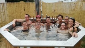 9 jeunes dans un bain nordique /jacuzzi au festival de Dour.  Zone Spa gérée par sauna Mobile